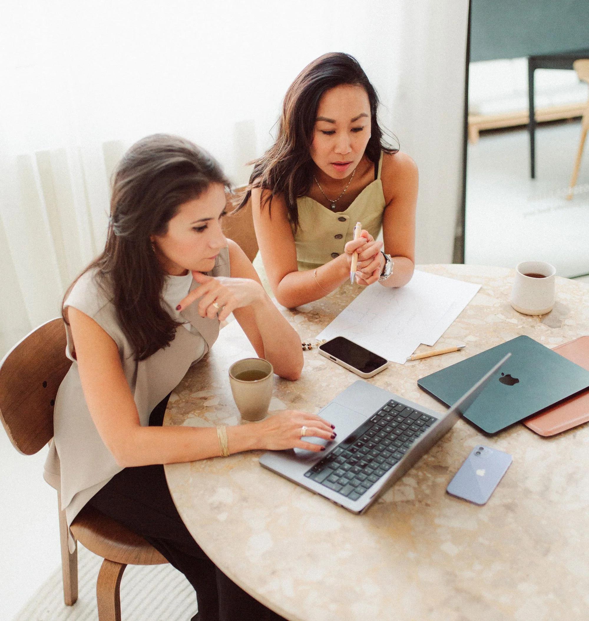 two women in candid discussion with paperwork