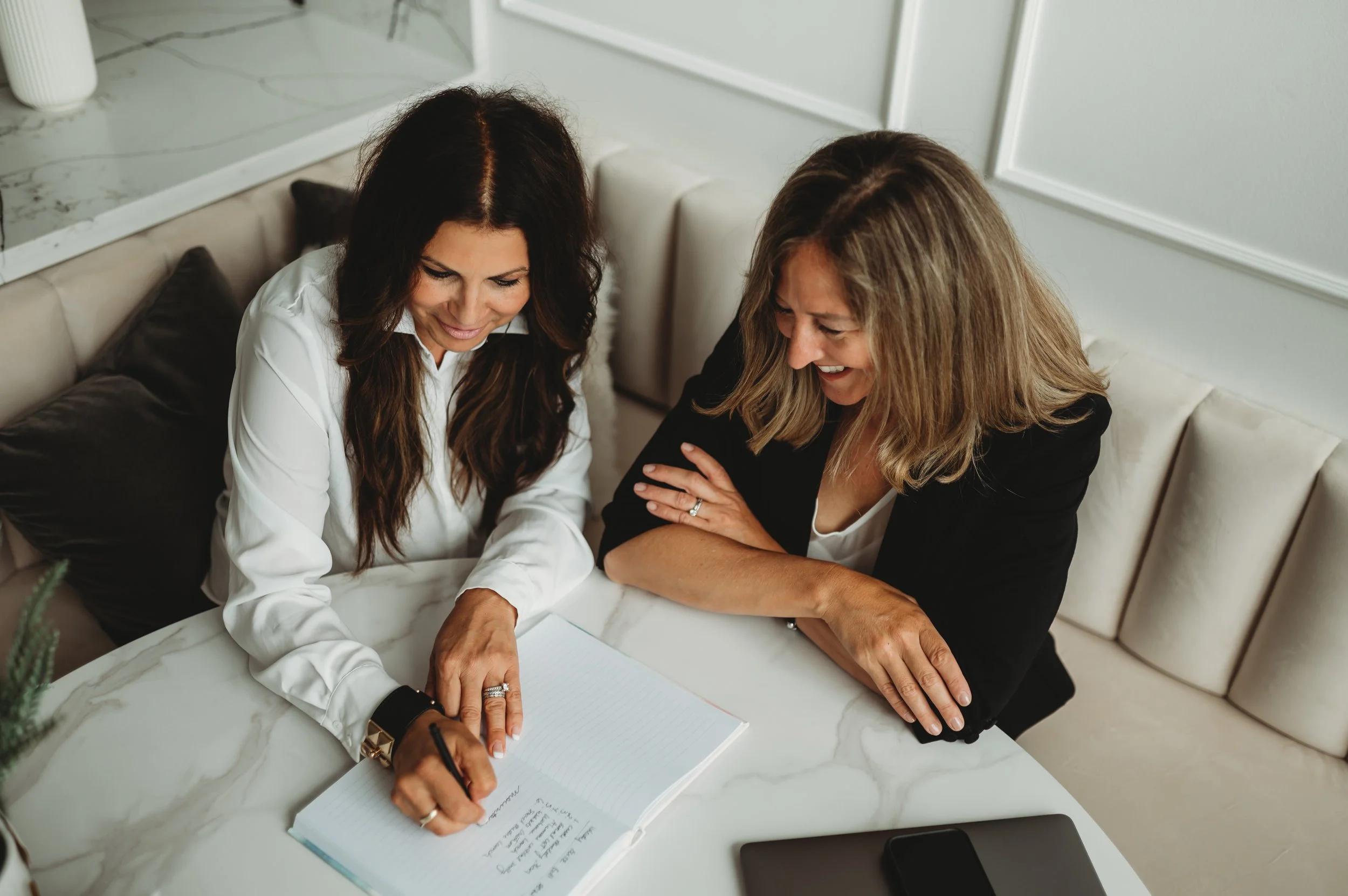 two women in candid discussion with paperwork
